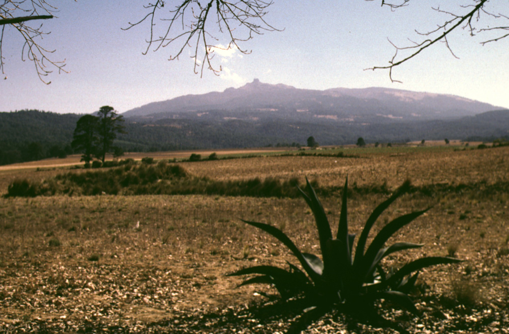 Cofre de Perote, sometimes referred to as the Treasure Chest of Perote, is seen here from the NW above fields near the town of Perote. The lower northern flanks of the largely Pleistocene volcano are overlain by ignimbrite deposits that erupted from the Los Húmeros caldera. Photo by Lee Siebert, 1998 (Smithsonian Institution).