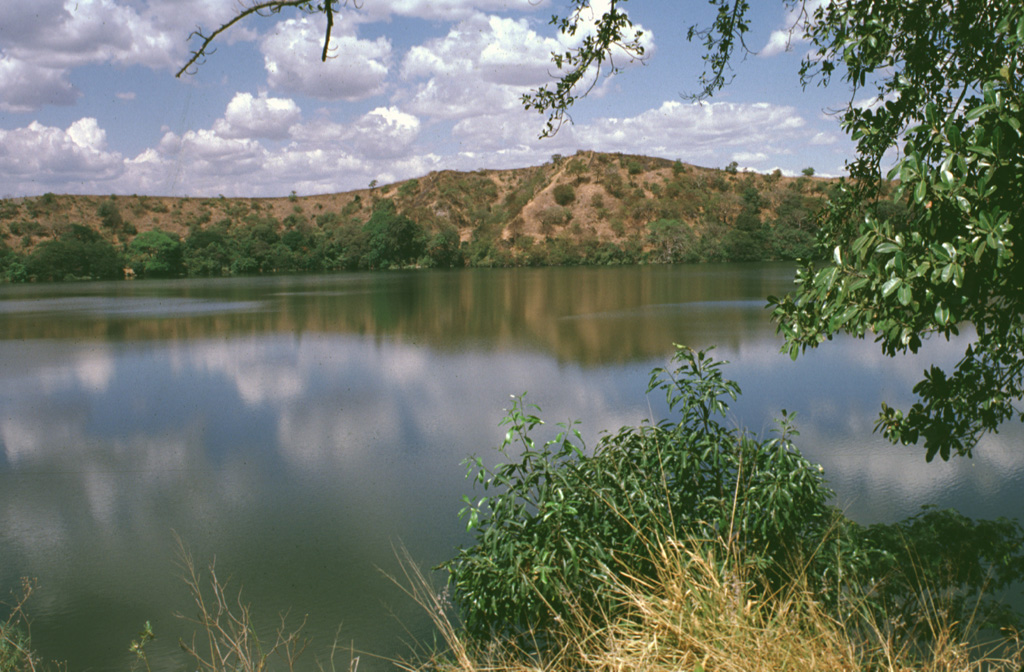 A solitary, 600-m-wide lake, Laguna Aramuaca, occupies a low-lying area about 10 km SE of the city of San Miguel.  The low northern wall of the maar is seen here from the southern rim of the 1-km-wide crater.  The Pan-American highway swings around the south side of the maar, which was erupted through sediments immediately north of the Río Grande de San Miguel.  The rim of the maar rises about 50-100 m above the countryside and reaches only 181 m above sea level.   Photo by Lee Siebert, 1999 (Smithsonian Institution).