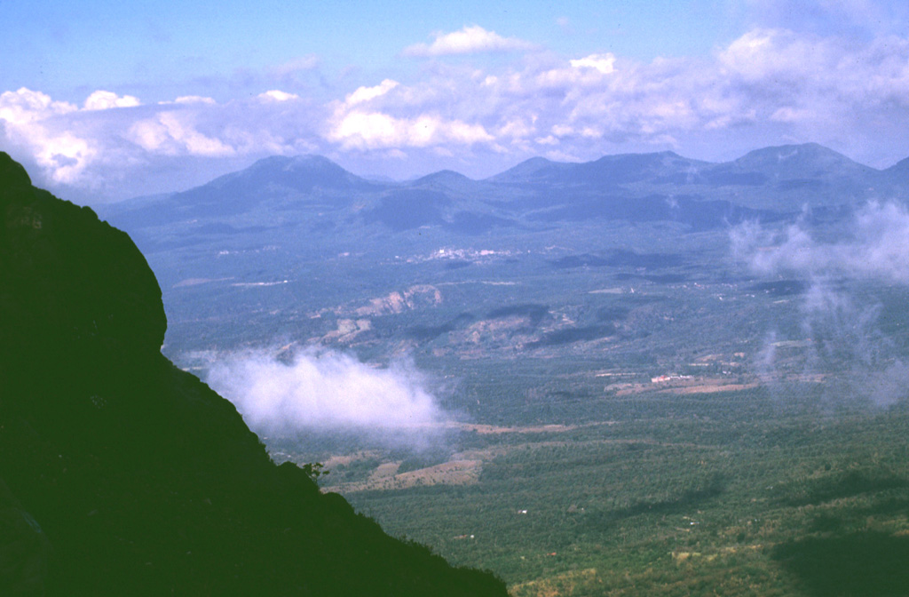 The summit of Izalco provides a view of the adjacent Apaneca Range volcanic complex to the west. The flat-topped edifice to the far-left is Cerro de Apaneca. The city of Juayua can be seen in the center of the photo. Above it is the small El Cerrito peak, and to its right is Cerro la Cumbre and the Cerro las Ninfas-Laguna Verde complex. Photo by Lee Siebert, 1999 (Smithsonian Institution).