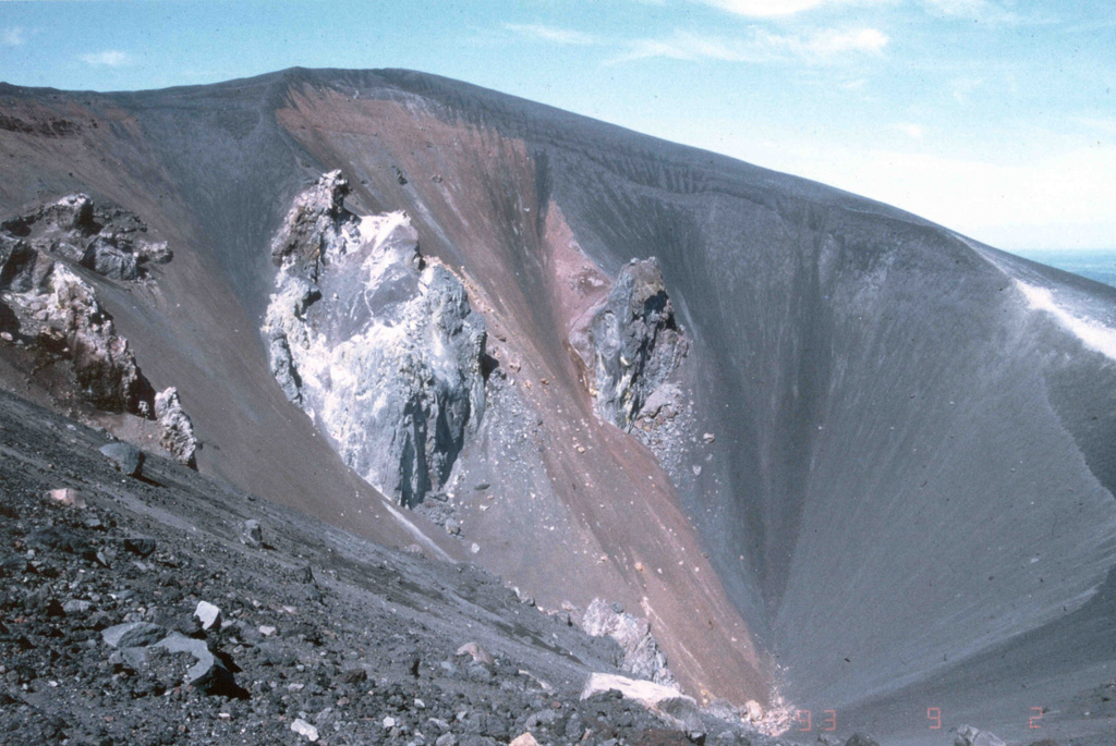This September 1993 photo shows the morphology of the crater of Cerro Negro volcano after the 1992 eruption.  Fumaroles observed during several visits by scientists to Cerro Negro on September 2-5 were issuing from circumferential fractures along the N rim of the crater and from what were interpreted as feeder dikes in the base of the crater.  Fumaroles along the crater rim exhibited weak and variable degassing, with temperatures ranging from 79 to 90°C.  Stronger fumaroles were confined to the feeder dikes within the crater. Photo by Andrew MacFarlane, 1993 (Florida International University).