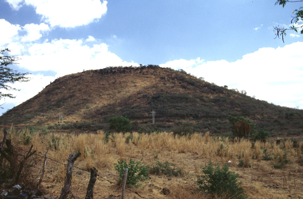 A group of scoria cones and low-elevation edifices surrounds the city of Jutiapa in SE Guatemala. This photo shows Volcán Culma, a cone largely composed of basaltic lavas on the eastern side of the city. The most prominent feature of the volcanic field is Cerro Santiago, one of two coalescing scoria cones SE of Jutiapa.  Photo by Giuseppina Kysar, 1999 (Smithsonian Institution).