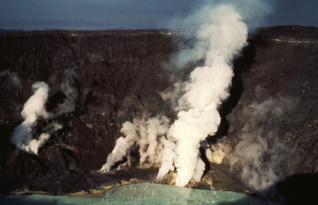 Gas-and-steam plumes emit from fumaroles on the crater floor of El Chichón volcano in January 1983. Gas and steam also rise from the hot, acidic crater lake in the foreground. Fumarole temperatures in the lower crater walls and floor ranged from 98 to 115°C. Photo by Bill Rose, 1983 (Michigan Technological University).
