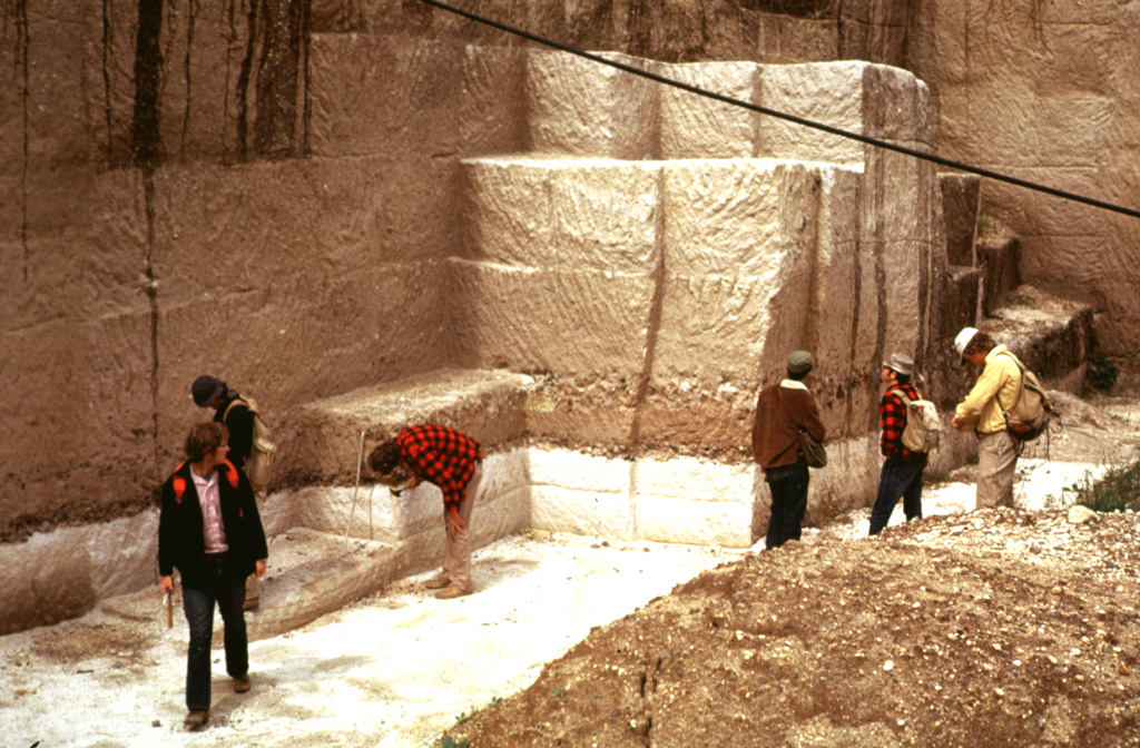 The 84,000-year-old Los Chocoyos Ash from Atitlán caldera is exposed in a quarry near San Juan Ostuncalco, west of Quetzaltenango. The white layer at the base is layer H, a rhyolite unit that is one of the largest known Plinian fall deposits in Central America. Despite its relative thinness, it is preserved over the entire Guatemalan highlands. The thicker overlying unit is the pyroclastic flow deposit, part of the Los Chocoyos ash. This massive unwelded pyroclastic flow deposit is up to 200 m thick. Photo by Bill Rose, 1974 (Michigan Technological University).