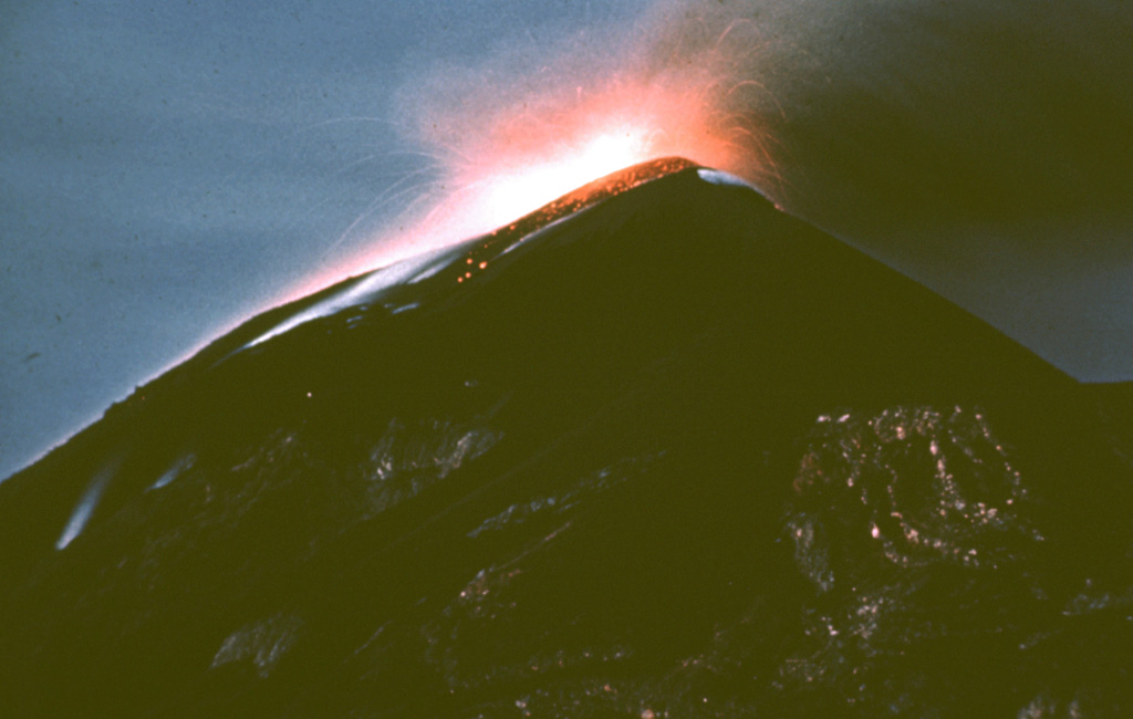 A nighttime exposure shows incandescent ejecta at the Fuego summit in 1962. Explosive activity and lava effusion took place during 4-20 August 1962. The August eruptions also produced pyroclastic flows. Eruptive activity resumed in October prior to a large explosive eruption on 9 November that produced a 12-km-high ash plume. During the November eruption much of the crater was filled with ejecta. Photo by Alfredo MacKenney, 1962 (courtesy of Bill Rose, Michigan Technological University).