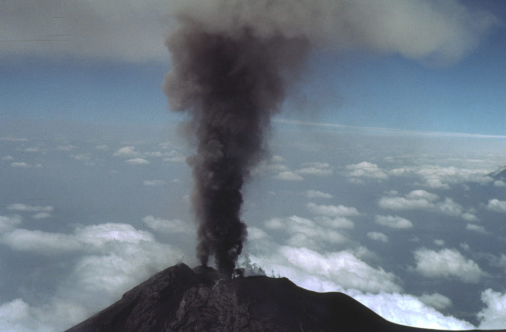 Two ash plumes rise simultaneously from small vents in the Fuego summit crater on 27 February 1978. This view is from the NE with the Pacific coastal plain in the background. Intermittent minor eruptions took place from 11 September 1977 to 8 August 1979. Strombolian eruptions from vents in the crater formed small cones and produced incandescent fountains at night. Photo by Bill Rose, 1978 (Michigan Technological University).