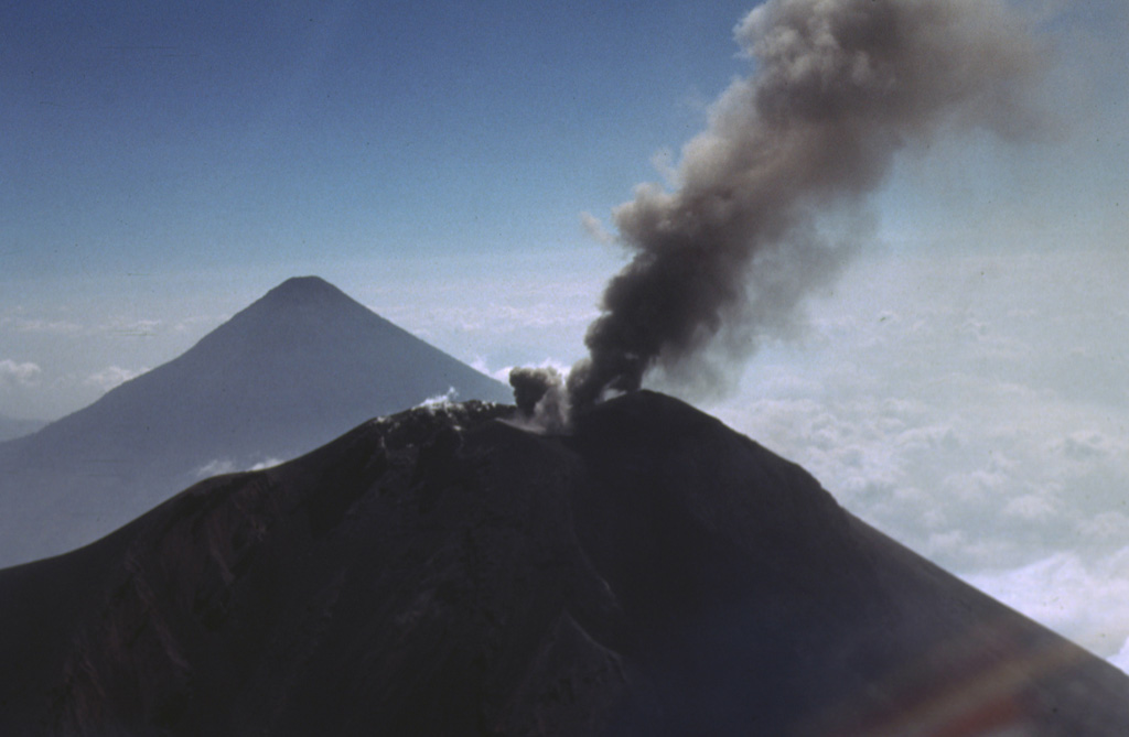 A small ash plume from the summit of Fuego on 27 February 1978 is deflected to the south as a second plume rises from another vent immediately to the left. Volcán de Agua is in the distance. Fuego erupted intermittently from September 1977 to August 1979. Photo by Bill Rose, 1978 (Michigan Technological University).
