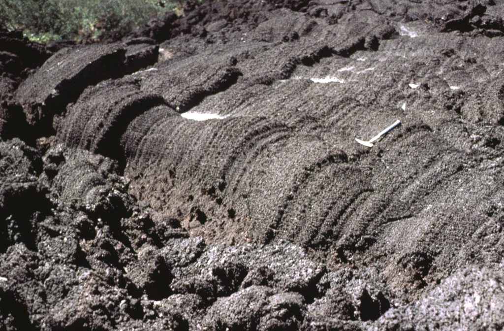 This lava flow surface were formed when still-fluid lava was squeezed through an irregular crack in previously solidified crust. Note the rock hammer at the right-center for scale. Frequent lava extrusion has occurred at Pacaya since 1965. Photo by Bill Rose, 1978 (Michigan Technological University).