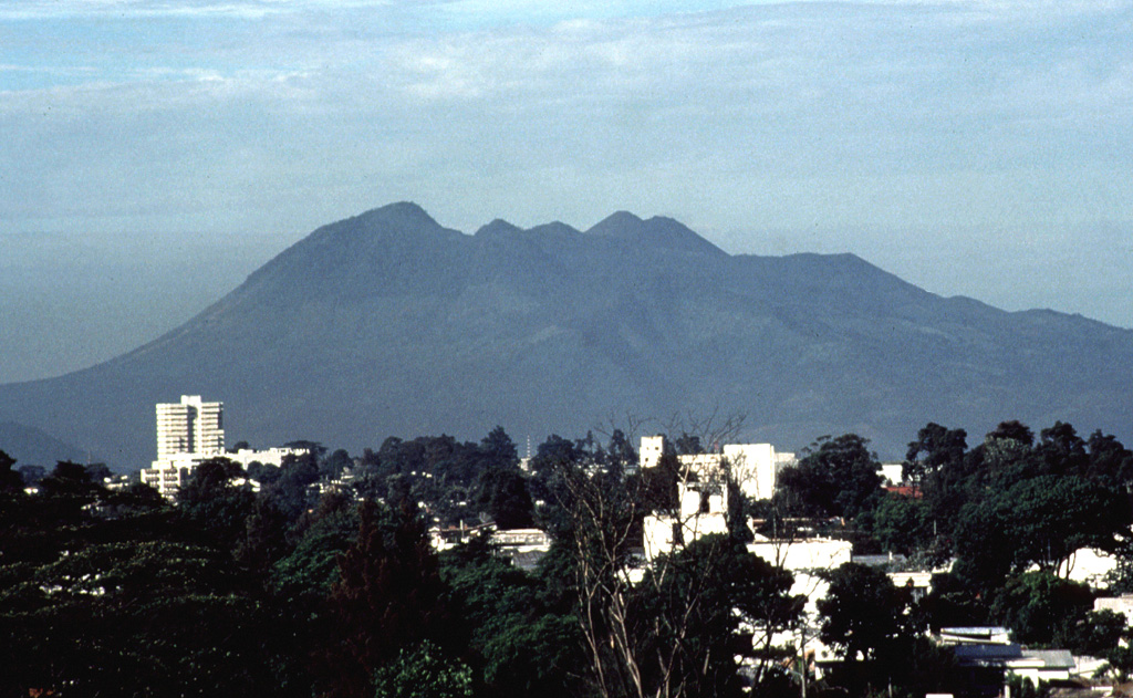 The Volcán de Pacaya massif rises above the capital city of Guatemala, located only 30 km to the north. The rounded, forested lava dome of Cerro Grande forms the high point at the left. The next highest peak to the right is the historically active vent of Pacaya, with the right-hand summit being the MacKenney cone, which has been active since 1965. Eruptions of Pacaya are often visible from Guatemala City. Photo by Bill Rose, 1989 (Michigan Technological University).