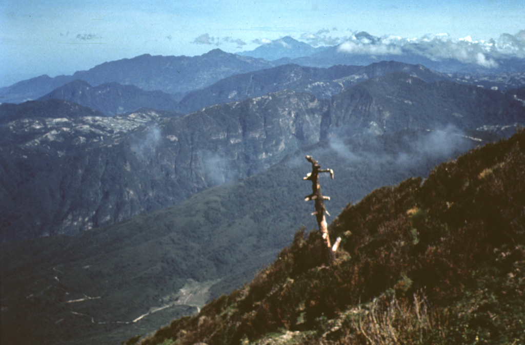 The deep valley cutting across the center of the photo is the elongated breached caldera of Siete Orejas volcano.  It is seen here from the SE from near the summit of Santa María volcano.  Light-colored areas on the caldera rim are voluminous rhyodacitic pumice deposits from Siete Orejas.  Tacaná volcano on the México/Guatemala border is on the left-center horizon, and Tajumulco is visible to its right.  These are the two highest volcanoes of Guatemala. Photo by Bill Rose, 1972 (Michigan Technological University).