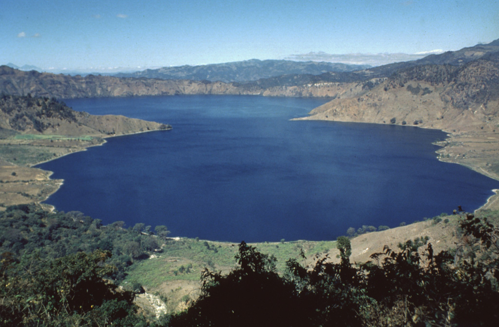 Ayarza, a scenic double caldera filled by Laguna de Ayarza, is seen here from the ESE.  The peninsulas of Punta el Picacho (left) and Punta el Picachito (right) lie across an 800-m-wide channel separating the two halves of the 5 x 7 km wide, figure-8-shaped caldera.  Both calderas, whose steep walls rise nearly 600 m above the lake surface, were formed within several thousand years of each other during major rhyolitic explosive eruptions in the late Pleistocene between about 27,000 and 23,100 years ago.   Photo by Bill Rose, 1980 (Michigan Technological University).