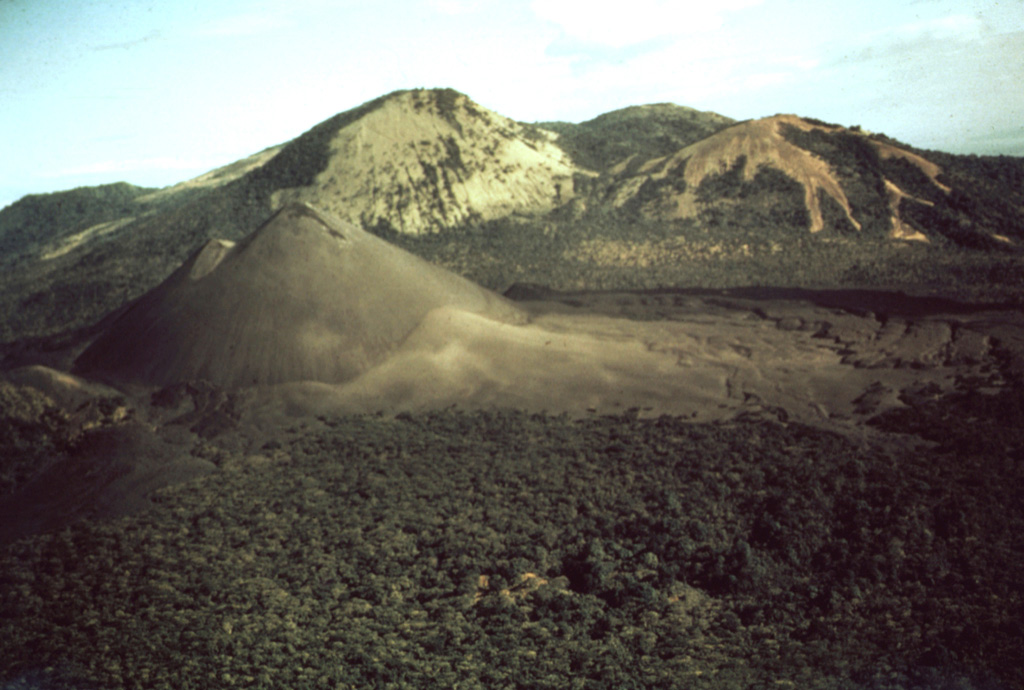 Cerro Negro, the unvegetated cinder cone at the left center, was born on April 13, 1850 on an uninhabited plain between Las Pilas (in the background) and Rota volcanoes.  The new cone reached a height of 50-60 m in ten days, after which activity subsided until renewing on May 27.  The tephra-mantled lava flow in the middle of the photo, extending from the western base of the cone to the forest in the foreground, was erupted in 1850.  The Las Pilas volcanic complex includes the peaks of Cerro Grande, Las Pilas itself, and Cerro Ojo de Agua. Photo by Willard Parsons, 1971 (courtesy of Bill Rose, Michigan Technological University).
