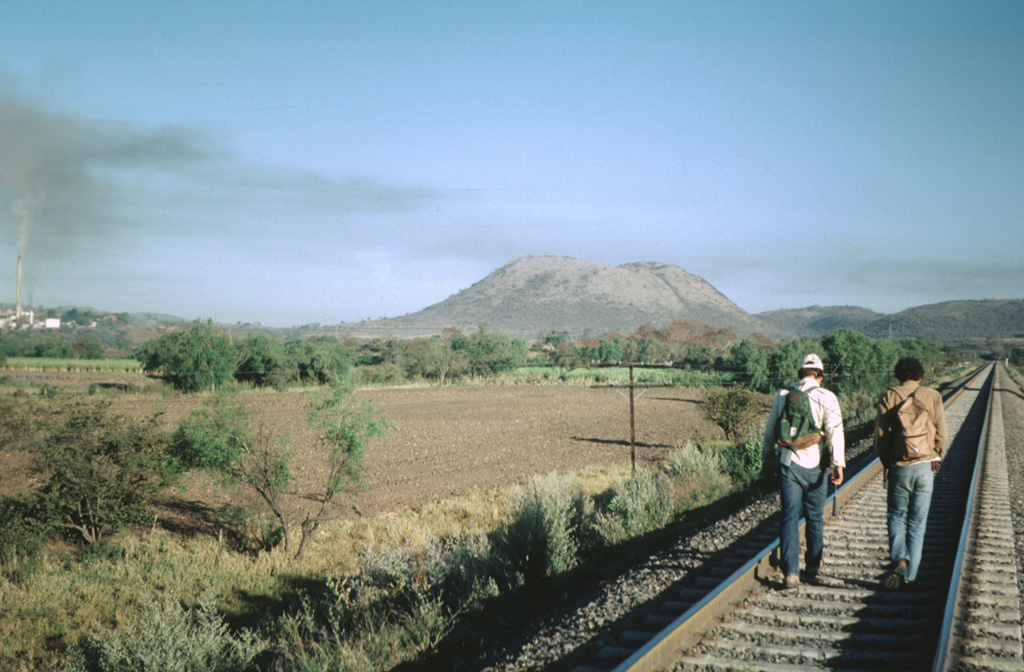 The flat-topped Cerro el Chino lava dome, seen here from the SSE, is a silicic lava dome of the Acatlán volcanic field.  This volcanic field, located SW of La Primavera caldera, consists of a group of andesitic cones, rhyolitic lava domes, and lava flows associated with an indistinct caldera.  Following eruption of the compositionally zoned Acatlán ignimbrite, a series of rhyolitic and dacitic lava domes, andesitic cones and lava flows, and Quaternary cinder cones were erupted throughout the Acatlán volcanic field.   Photo by Jim Luhr, 1981 (Smithsonian Institution).
