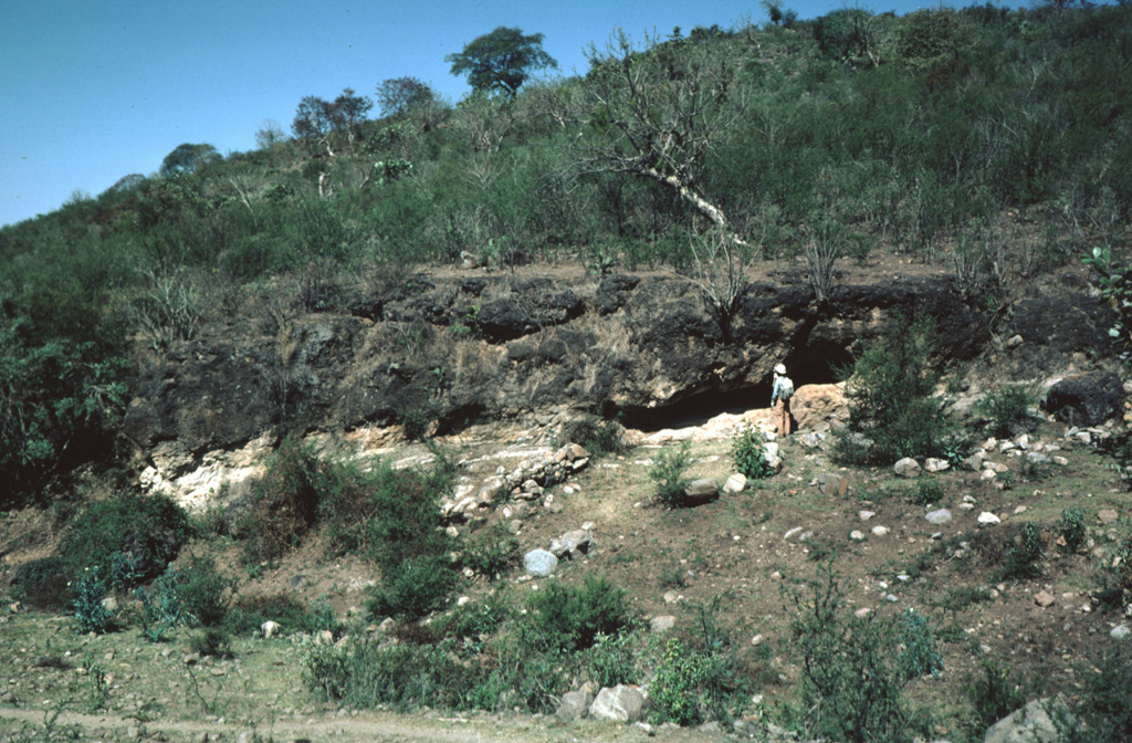 The Acatlán Ignimbrite covers 150 km2. It is compositionally zoned, grading from a white-or-pink colored basal rhyolitic tuff to a black upper andesitic tuff.  The upper andesitic tuff is welded in the western part of the deposit, with the degree of welding increasing towards the top. Photo by Jim Luhr, 1983 (Smithsonian Institution).