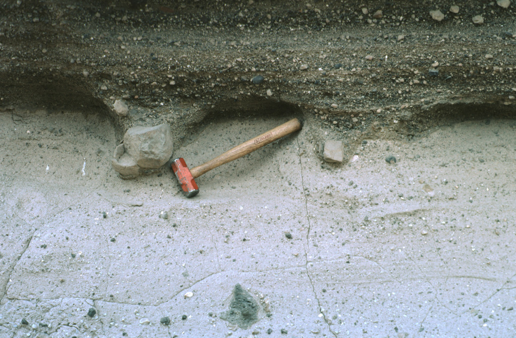 Large lithic blocks in tuff breccias of the Joya de Los Contreras maar form bomb sags that are exposed in three dimensions by differential erosion.  The blocks impacted into the previously deposited lighter-colored tuffs, and the pits were subsequently filled by darker-colored crudely laminated surge deposits.  The Joya de Los Contreras maar,  750 m by 1000 m wide, is the largest of the Santo Domingo volcanic field. Photo by Jim Luhr, 1991 (Smithsonian Institution).