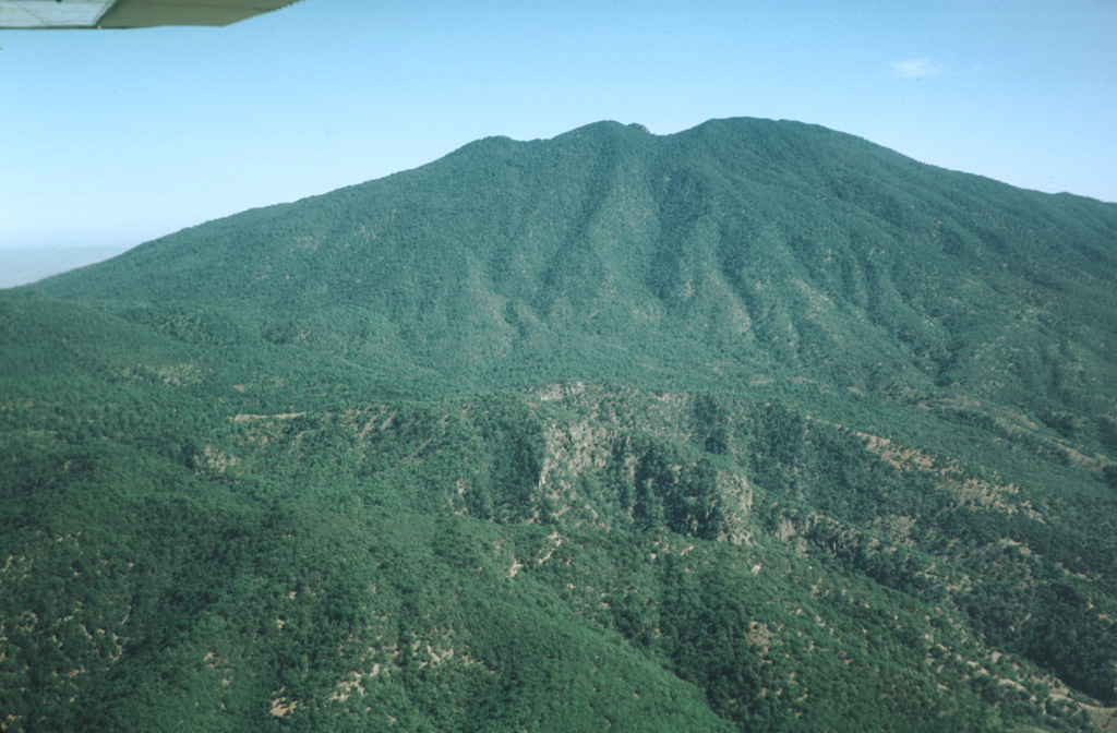 The south flank of the erosionally modified Tequila volcano is seen in an aerial view.  The oldest lava flows from the Pleistocene stratovolcano overlie a south-flank rhyolitic lava dome dated at about 460,000 years.  Summit crater activity ceased about 210,000 years ago, but flank eruptions producing andesitic lava flows and basaltic cinder cones continued until the late Pleistocene. Photo by Jim Luhr, 1979 (Smithsonian Institution).