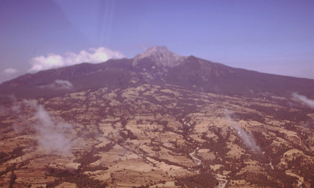 Broad alluvial fans composed of fluvial, glacial, and volcaniclastic sediments surround La Malinche volcano. The circular volcano is dissected by radial drainages on all sides. During attempts to reconstruct the Quaternary glacial history of Mexican volcanoes a yellowish-red pumice layer that extends around Malinche volcano was dated to between about 12,100 and 7,650 years old. Photo by Gerardo Carrasco-Núñez, 1997 (Universidad Nacional Autónoma de México).