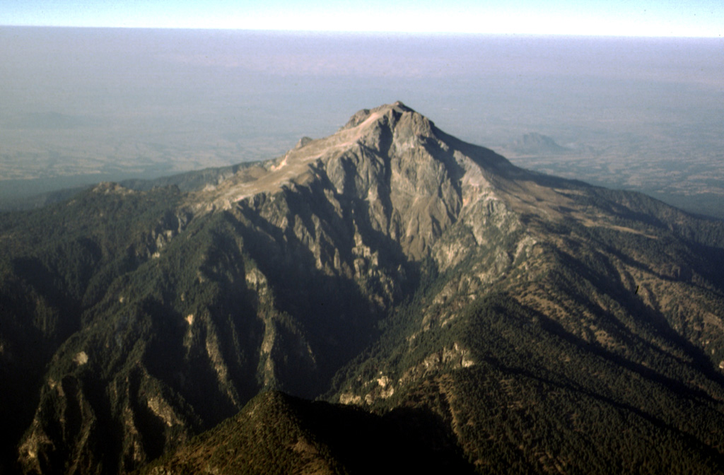 Malinche is located between the Popocatépetl-Iztaccíhuatl and Orizaba-Cofre de Perote volcanic ranges. The edifice is largely Pleistocene in age and is seen here in an aerial view from the SE. The canyons on the flanks are a result of glacial erosion. Holocene lahars from La Malinche associated with an eruption about 3,100 years ago reached the Puebla basin and affected precolumbian settlements. Photo by Gerardo Carrasco-Núñez, 1997 (Universidad Nacional Autónoma de México).