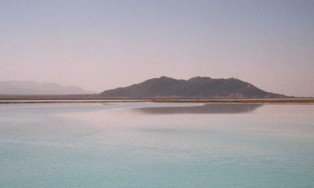 The Cerro Prieto lava dome is seen here beyond an evaporation pond of the Cerro Prieto geothermal field at the head of the Gulf of California, 35 km south of the city of Mexicali. The first geothermal power plants began operation at Cerro Prieto in 1973; nine power plants and about 130 wells were in operation in 1997. Photo by Pat Dobson, 1998 (Lawrence Berkeley National Laboratory).