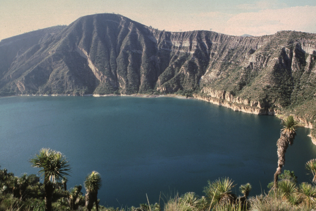 The Atexcac maar is one of several lake-filled maars of the Serdán-Oriental volcanic field. The walls expose pyroclastic surge beds produced during formation of the maar. Cretaceous limestone beds and remnants of a basaltic scoria cone partially destroyed during formation of the maar are also exposed in the western crater walls. Abundant juvenile obsidian clasts are found in the surge deposits. Photo by Hugo Delgado-Granados, 1997 (Universidad Nacional Autónoma de México).