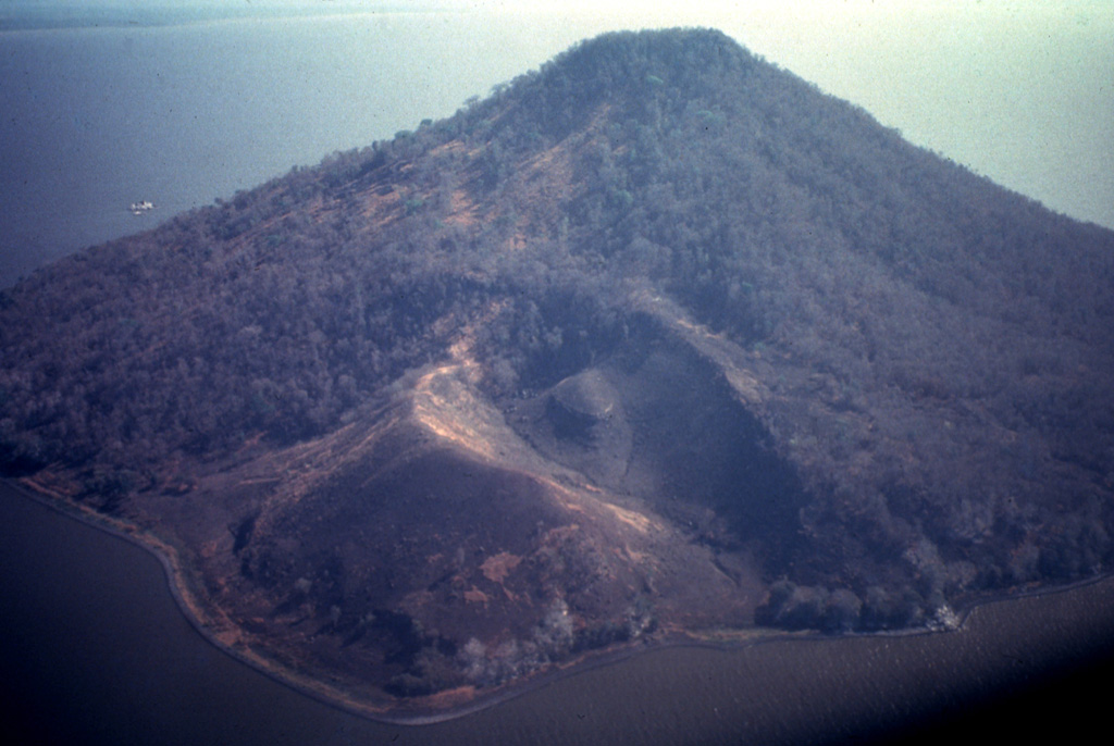 Isla Momotombito is a small 391-m-high island located immediately SE of Momotombo about 4 km off the coastline of Lake Managua.  Punta Santa Ana, the peninsula in the foreground, consists of a young pyroclastic cone on the WSW side of the uninhabited, rattlesnake-infested island.  Numerous archaeological sites have been found on the island. Photo by Jaime Incer, 1993.
