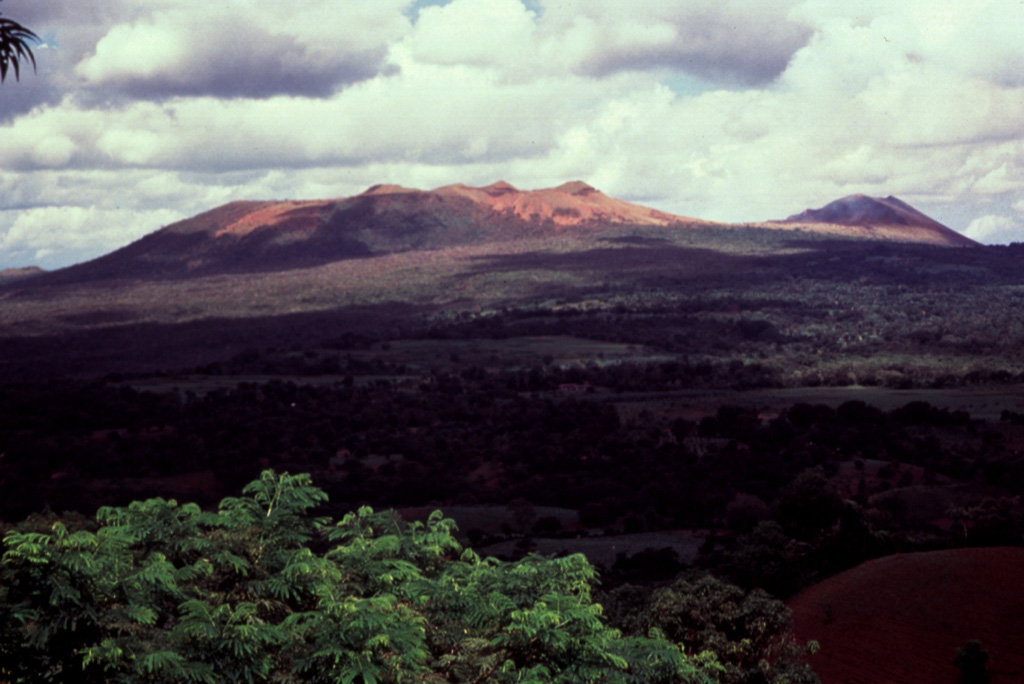 The Masaya central cone complex within the Holocene Masaya caldera (foreground) lies within a larger Pleistocene caldera, the Las Sierras (or Las Nubes) caldera, which was formed following the eruption of a major ignimbrite about 30,000 years ago.  The ignimbrite deposit from this eruption is found in the Managua area, where it is cut by faults of the Managua Graben, which extends to the north, constraining the SE margins of Lake Managua. Photo by Jaime Incer, 1990.