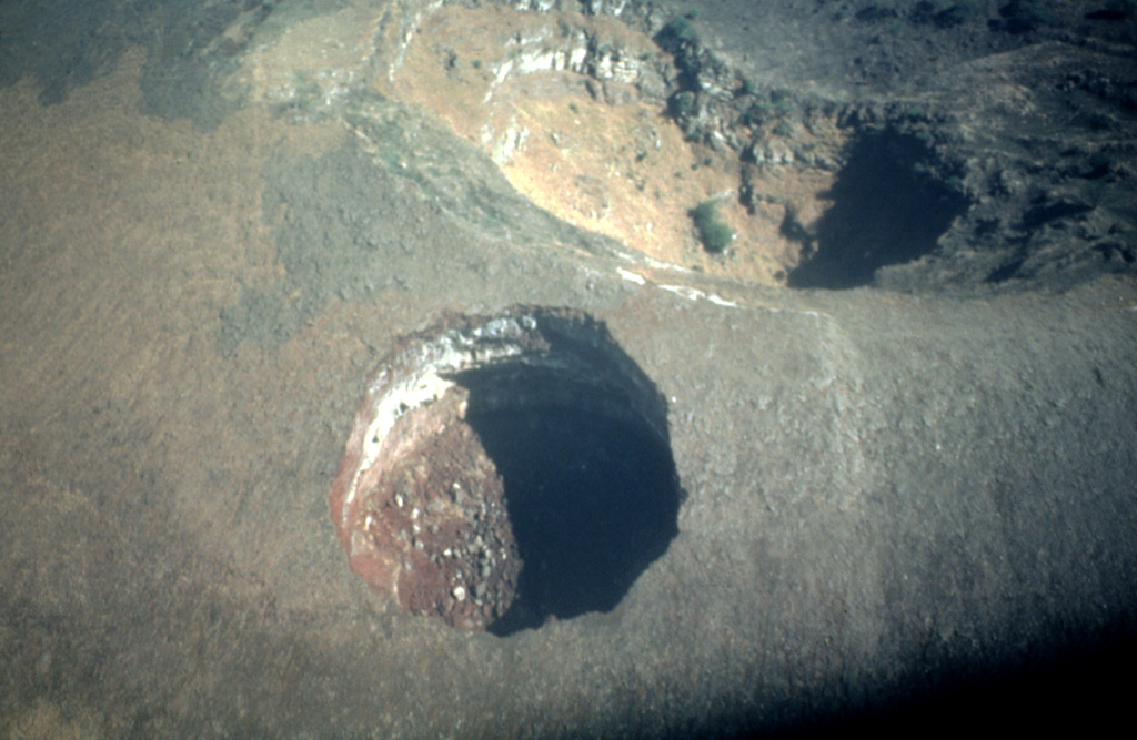This dramatic near-vertical aerial photo looks down on El Hoyo, a spectacular pit crater near the summit of Las Pilas volcano.  The pit crater, approximately 100 m in diameter, was formed by collapse.  El Hoyo is located immediately south of the rim of the 700-m-wide summit crater of Las Pilas (upper right). Photo by Franco Penalba, 1993 (courtesy of Jaime Incer).
