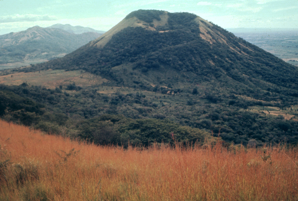 Volcán Santa Clara lies across a 400-m-high saddle (left) from Telica volcano.  The crater rim of 834-m-high Santa Clara is higher on its far SE side and is breached to the NW.  Santa Clara was considered to be active during the 16th century, but these reported eruptions more likely originated from Telica. Photo by Alain Creusot-Eon, 1977 (courtesy of Jaime Incer).