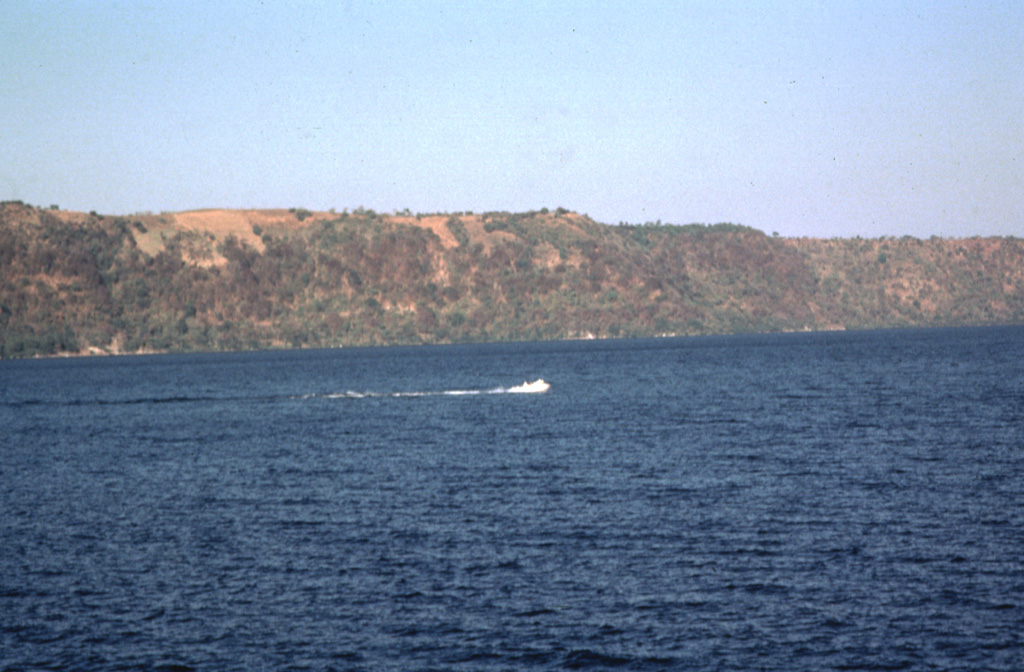 The circular Apoyo caldera is filled by beautiful Laguna de Apoyo.  The NE caldera wall in the background rises about 120 m above the surface of the lake, which is only 78 m above sea level.  The only road access to the lake is along its western shore.  The caldera was formed by collapse along near-vertical faults following two major dacitic explosive eruptions about 23,000 years ago from a vent area inferred to be near the NE part of the caldera.  Photo by Jaime Incer.