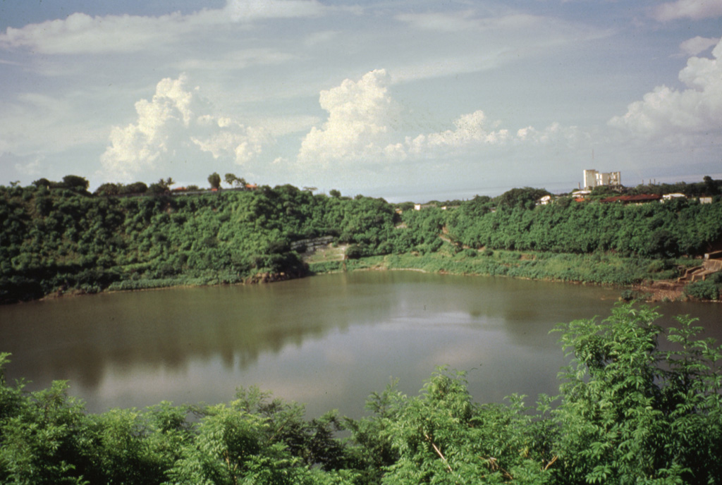 Laguna de Tiscapa is seen here from the SW with a skyscraper of downtown Managua in the right background.  The 700-m-wide maar overlooks the central part of the city.  Laguna de Tiscapa lies about 5 km east of the Nejapa-Miraflores crater lineament along a major fault that cuts through the city of Managua. Photo by Jaime Incer.