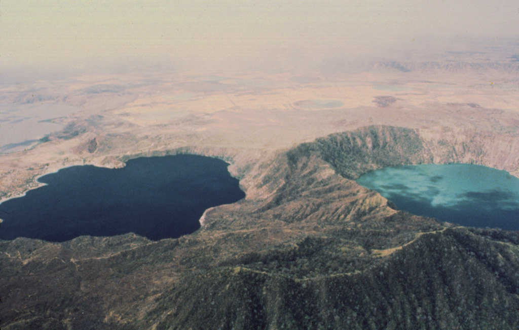 The deep blue Laguna de Jiloa (left) and the turquoise-colored Laguna Apoyeque dramatically fill two calderas on the Chiltepe Peninsula north of Managua.  The 2.8-km-wide Apoyeque caldera, the source of the major Chiltepe Pumice about 2000 years ago, has a more circular outline than the scalloped 2.5 x 3 km wide Jiloa caldera, which was the site of a major explosive eruption about 6500 years ago. Photo by Jaime Incer, 1980.