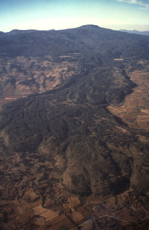 Volcán Tláloc, the broad volcano on the horizon, is one of the larger volcanic centers of the eastern part of the Chichinautzin volcanic field. It erupted about 6,200 years ago and is seen here from the east with a large lava flow in the foreground.  Photo by Hugo Delgado, 1994 (Universidad Nacional Autónoma de México).