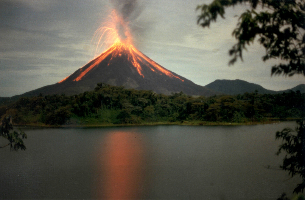 A Strombolian eruption is seen here at Arenal on 15 June 1997. The oldest known Arenal products are about 7,000 years old, and the volcano was active for several thousand years contemporaneously with the older Chato volcano (lower right). A recent eruptive period began with a major explosive event in 1968, and frequent explosive activity and slow lava effusion continued through to 2010. Photo by Olger Aragón, 1997.