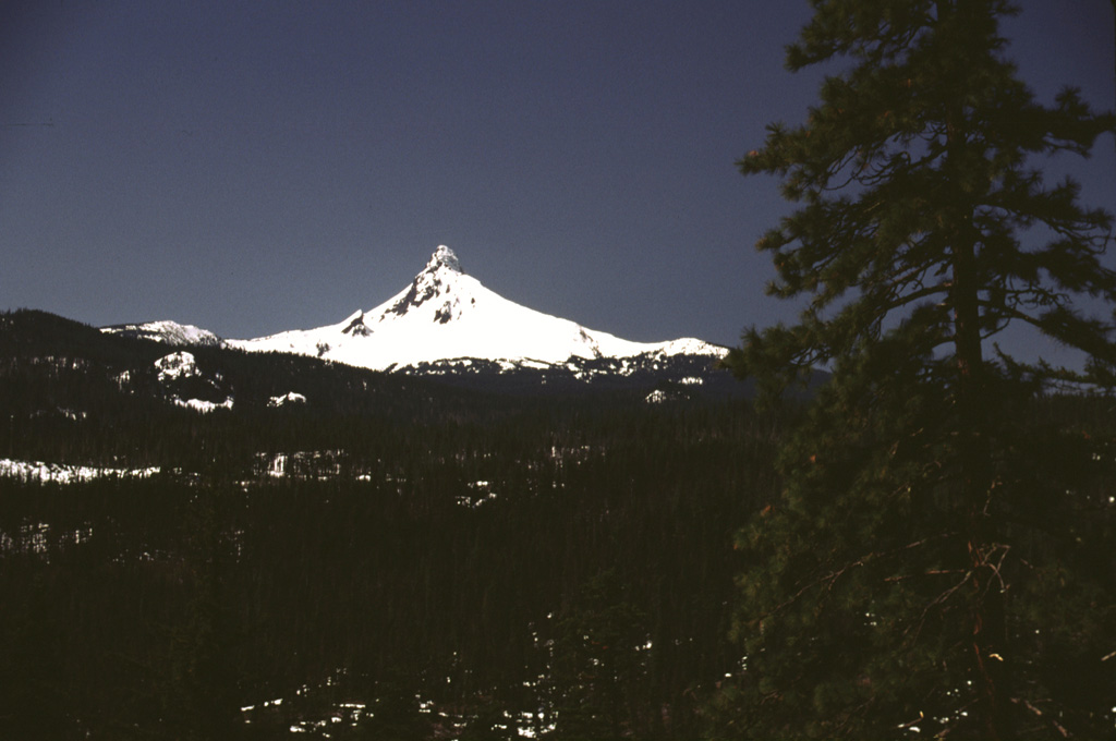 Early spring snows linger on the dramatic spine of Mount Washington, seen here from the east, north of Santiam Pass.  Washington is of several major Pleistocene Cascade volcanoes, including Mount Thielsen, North Sister, and Mount Jefferson, whose resistant central conduit has been exposed by erosion. Photo by Lee Siebert, 2000 (Smithsonian Institution).