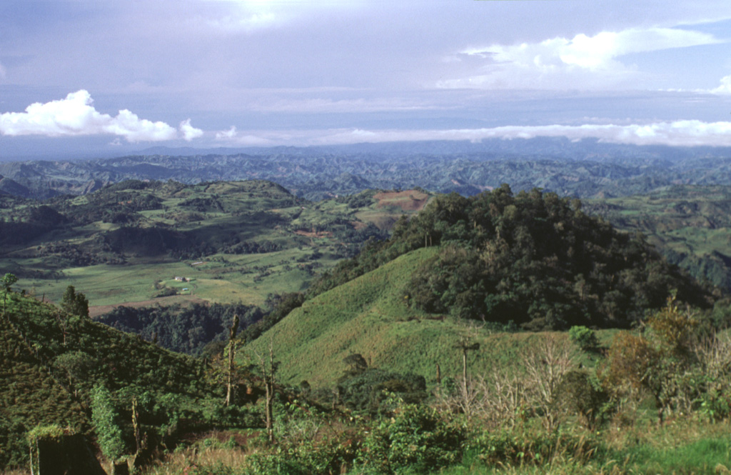 The irregular, hummocky terrain extending to the SW toward the Pacific coastal plain is part of a massive debris-avalanche deposit that originated from edifice collapse of Volcán Tisingal.  This view is from Cerro Pando, a satellitic lava dome south of Volcán Colorado.  Both volcanoes of the Barú-Colorado complex underwent edifice failure, producing voluminous debris-avalanche deposits that form a broad blanket reaching beyond the Panamerican highway to the Pacific coastal plain. Photo by Lee Siebert, 1998 (Smithsonian Institution).