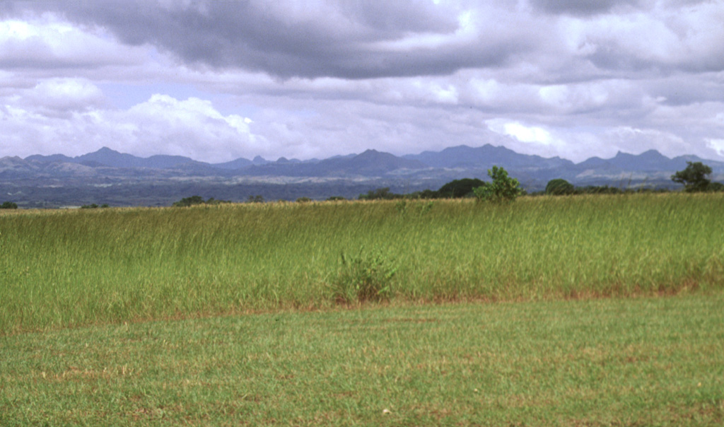 The broad irregular ridge on the horizon NE of the Pacific coastal plain is El Valle volcano in Panama. El Valle de Antón caldera is within the volcanic complex and post-caldera lava domes can be seen in the center of the horizon. Late-Pleistocene Plinian eruptions from El Valle have produced pyroclastic flows that reached the coast. Tertiary volcanic centers surround the caldera complex. Photo by Lee Siebert, 1998 (Smithsonian Institution).