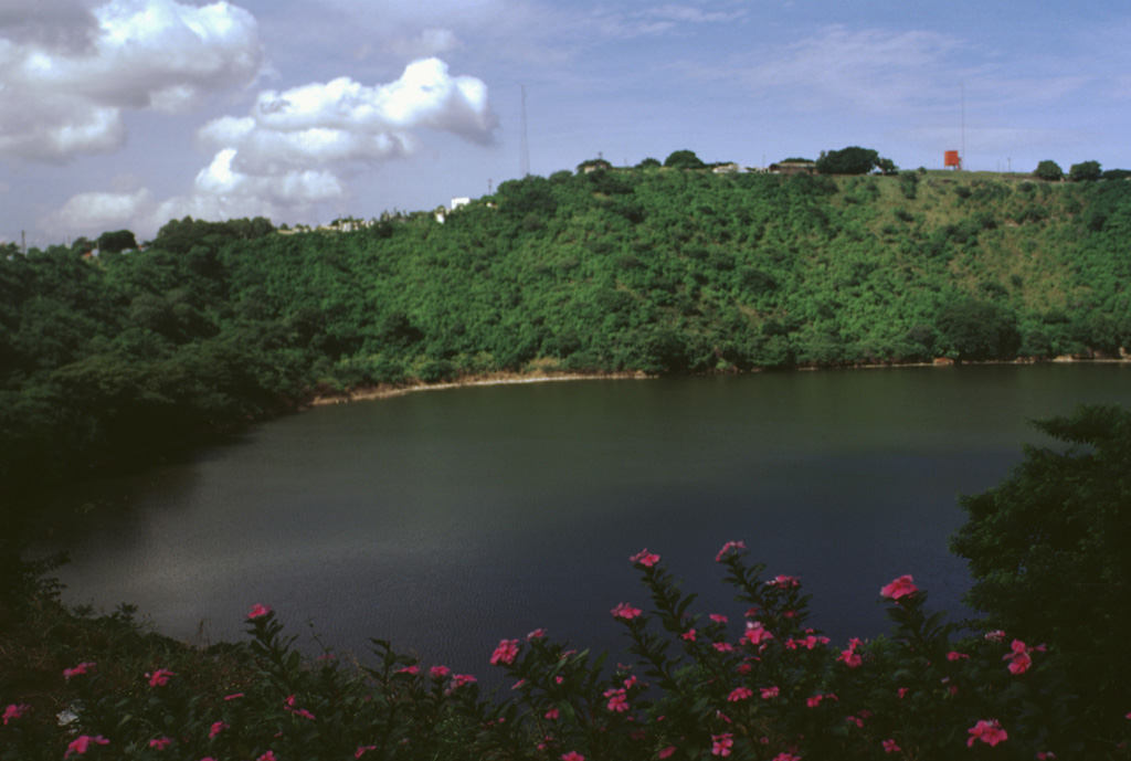 A restaurant on the rim of Laguna de Tiscapa provides a scenic view of the a 700-m-wide maar on the outskirts of Managua, Nicaragua's capital city.  The maar was constructed along a major fault that cuts through Managua.  The crater overlooks the center of Managua and lies 5 km east of the N-S-trending Nejapa-Miraflores lineament, a 17-km-long chain of collapse pits and cinder-spatter cones that marks a point of right-lateral offset of the Nicaraguan volcanic chain. Photo by Lee Siebert, 1998 (Smithsonian Institution).