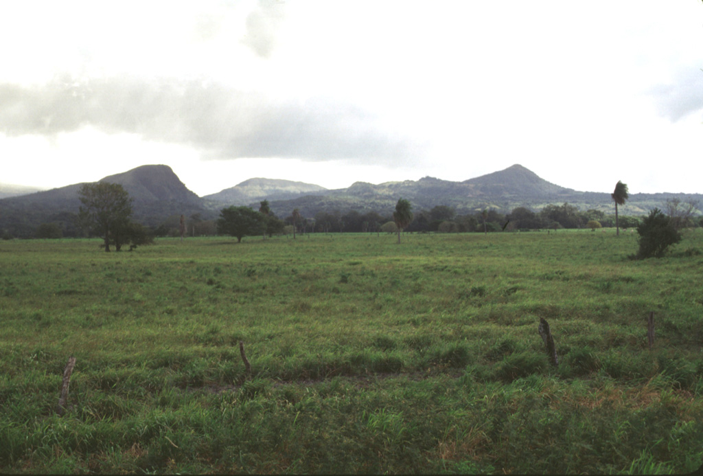 Cerro San Roque (left), Cerro Gongora (center), and Cerro Cañas Dulces (right) lava domes, seen here from the west along the Pan-American highway, are just outside the Guachipelín caldera. The domes formed prior to the eruption of the Liberia Tuff and formation of the caldera about 1.6 million years ago. Photo by Lee Siebert, 1998 (Smithsonian Institution).