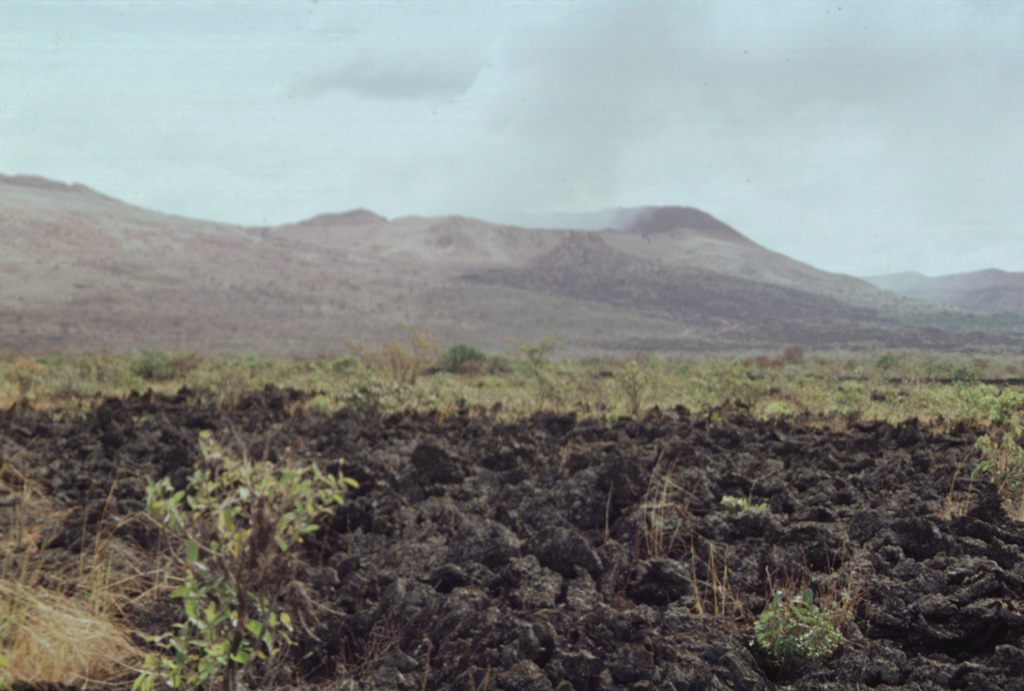 The blocky lava flow in the foreground was erupted in 1772 from a vent on the northern side of Old Masaya cone (extreme left).  The dark flow at the upper right spilling over the rim of Nindirí crater was erupted in 1670 and traveled down the northern flank of the cone. Photo by Paul Kimberly, 1998 (Smithsonian Institution).