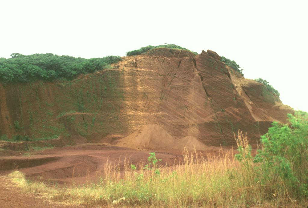The interior of the Cerro Chopo pyroclastic cone has been exposed by extensive quarrying operations to provide aggregate materials for road construction.  Reverse grading can be observed in walls produced by the quarrying.  The cone rises about 250 m above its base to 402 m elevation.   The crater is oriented to the NW and was the source of olivine-basaltic lava flows.  Photo by Lee Siebert, 1998 (Smithsonian Institution).
