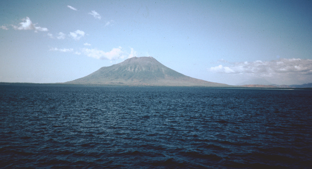 Lewotolo, seen here from the Flores Sea NW of the volcano, anchors the eastern end of the northern peninsula that is connected to Lomblen Island by a narrow isthmus.  Many lava flows have reached the coastline of the peninsula.  Historical eruptions from Lewotolo have been recorded since 1660 and have consisted of explosive activity from the summit crater.     Photo by Rob McCaffrey, 1982 (Rensselaer Polytechnic Institute).