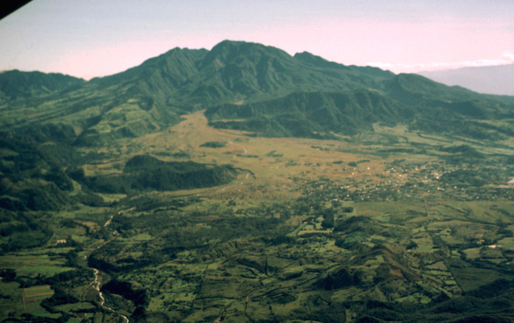 The large flank collapse scar of Volcán Barú is seen here from the west, with its northern wall extending downward left of the summit. The summit itself is a large lava dome complex constructed within the scarp near its eastern headwall. The vegetated horizontal N-S-trending ridge below and to the right of the summit dome complex are segments of the former edifice that slid down intact. The towns of Nuevo California and Hato del Volcán are at the base of the volcano to the right. Photo by Kathleen Johnson, 1998 (University of New Orleans).