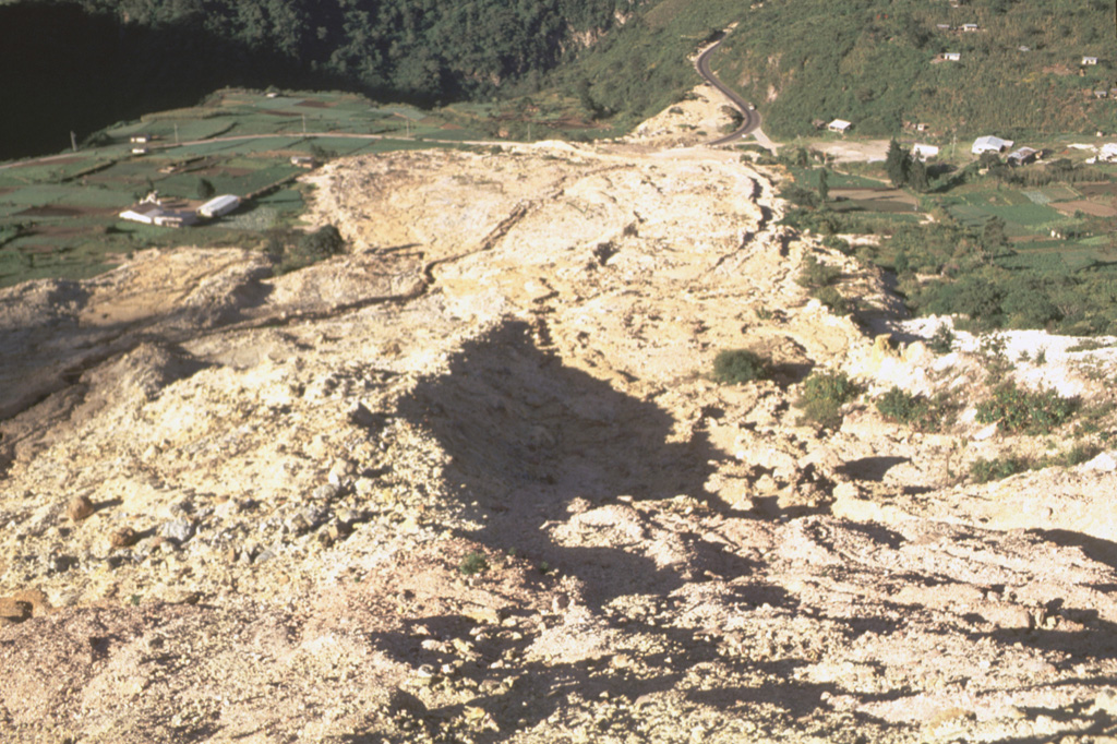This view looks down the path of the 5 January 1991 landslide at the Almolonga volcano Zunil geothermal site. The avalanche of extensively hydrothermally altered material along the Zunil fault zone traveled 800 m from its source. The slide nearly reached the Río Samala and can be seen at the top of the photo cutting the highway between Quetzaltenango and Retalhuleu. The deposit has four overlapping lobes with a combined thickness of 2-3 m. Photo by Claus Siebe, (Universidad Nacional Autónoma de México).
