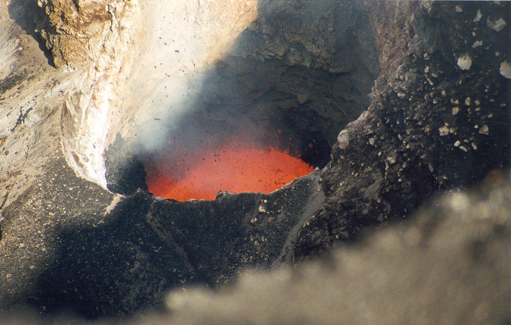 Incandescent spatter ejected from a new lava lake at vent C of Mbwelesu crater at Ambrym volcano on 28 August 1999. Mbwelesu was constructed at the eastern rim of Marum crater in the west-central part of the 12-km-wide summit caldera. More frequent lava lake activity had been reported from several craters within the caldera since at least 1996. Lava lake activity had also been previously noted by infrequent visitors to the summit caldera during the late 1980s and early 1990s. Photo by John Seach, 1999.