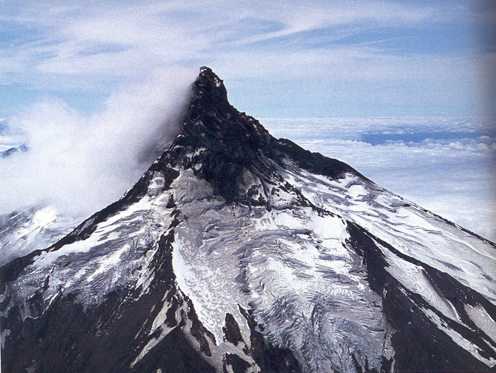 The dramatic summit spire of Volcán Puntiagudo forms one of the most spectacular volcanic peaks of the Andes.  The summit pinnacle, formed as a result of extensive glacial erosion, exposes the volcano's resistant central conduit.  Puntiagudo-Cordón Cenizos volcanic chain lies between Lago Rupanco and Lago Todos Los Santos in the Chilean lake district.  An 18-km-long fissure system with late-Pleistocene to Holocene scoria cones and small stratovolcanoes extends to the NE and was last active in 1850.   Photo by Oscar González-Ferrán (University of Chile).