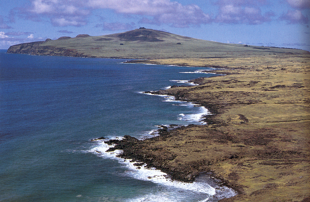 Waves lap against the northern coast of Easter island.  This view looks from Obahe to Mahatua with Volcán Poike, a shield volcano forming the eastern tip of the island, on the horizon.  The trachytic lava domes of Tea-Tea are the small peaks on the left horizon.  The triangle-shaped Easter Island, renowned for its dramatic megalithic statues of hand-carved basalt, sits atop the Sala y Gómez submarine ridge, which trends eastward from the East Pacific Rise.  The island is composed of three principal volcanoes, Poike, Rano Kau, and Terevaka. Photo by Oscar González-Ferrán (University of Chile).