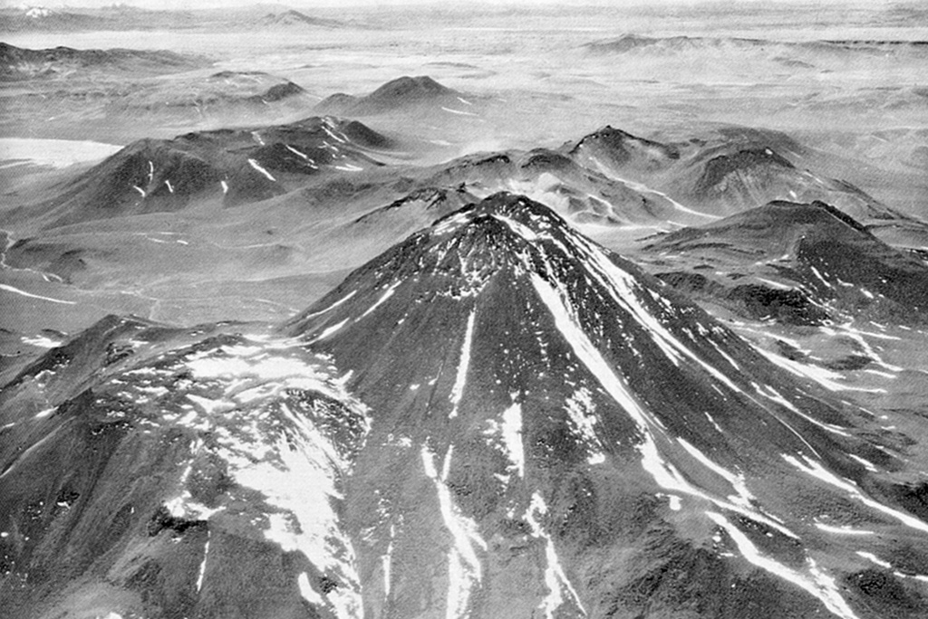 The western flank of Acamarachi volcano is seen in an aerial view with ignimbrite deposits of the Pliocene La Pacana caldera in the background.  This steep-sided andesitic volcano, also known as Cerro Pili, rises to 6046 m.   Photo by Insitituto Geográfico Militar, courtesy of Oscar González-Ferrán (University of Chile).
