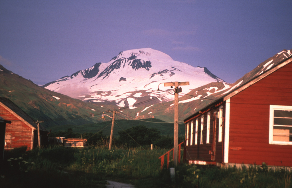 Glacier-covered Roundtop volcano is seen here to the west of False Pass village, is the easternmost and lowest of an E-W-trending line of volcanoes on Unimak Island. Roundtop has produced Holocene pyroclastic flows, and a group of lava domes to the south. Photo by Game McGimsey, 1998 (Alaska Volcano Observatory, U.S. Geological Survey).