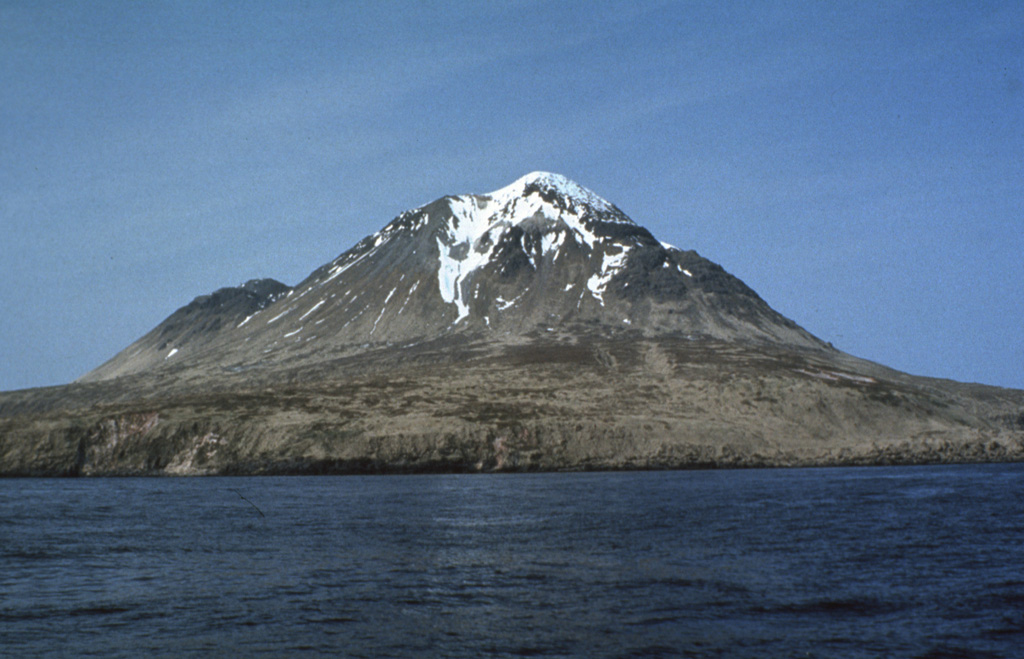 The southern half of 5 x 10 km Kagamil Island in the NE part of the "Islands of Four Mountains" group contains two postglacial cones with small summit craters. The larger cone (center) is seen here from the SW and is located at the SE end. Hot springs and fumaroles occur near the SE coast.  Photo by G. Vernon Byrd, 1972 (U.S. Fish and Wildlife Service, courtesy of Alaska Volcano Observatory).