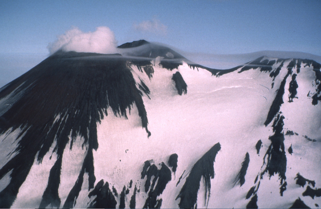 Two peaks form the summit ridge of Gareloi. The active NE-most crater (left) forms the high point of the island. A SE-trending 4-km-long fissure formed during an eruption in 1929, extends from the summit (right) to the sea and contains 13 vents.  Phreatic explosions were followed by the ejection of pumice, lapilli, scoria, and lithics, as well as by the emission of four short lava flows. Photo by Fred Zeillemaker, 1986 (U.S. Fish & Wildlife Service, courtesy of Alaska Volcano Observatory).