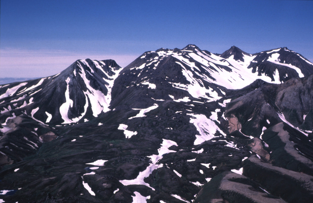 Most of the 3.5-km-wide caldera floor of Black Peak volcano, located NW of Chignik Bay, contains the complex of lava domes seen here. The ice-free mid-Holocene caldera contains two small lakes. Pyroclastic flow and block-and-ash-flow deposits from the caldera-forming eruption filled the Ash Creek and Bluff Creek valleys to the west and north less than about 4,000 years ago. Photo courtesy of Alaska Volcano Observatory, U.S. Geological Survey, 1979.